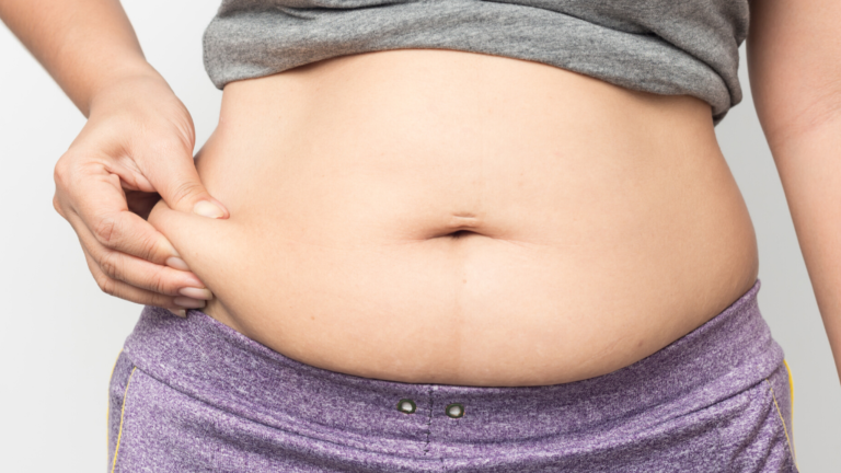 Man holding abdominal fat related to hormonal weight gain