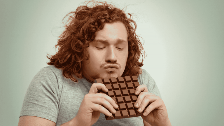 Man looking at fast food and sweets linked to food cravings