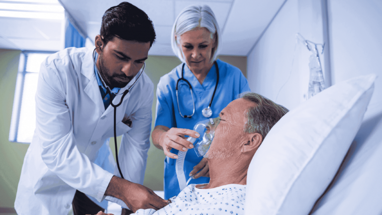 Doctor and nurse assisting hospital patient with oxygen mask