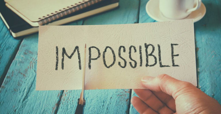 Card with the word Impossible being altered with a pencil