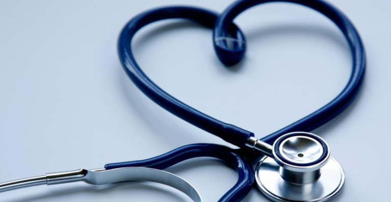 Stethoscope shaped into heart symbol on white background