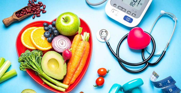 Heart-shaped plate with fresh vegetables and fruits beside medical equipment