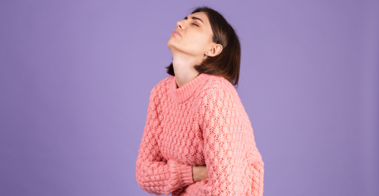 Woman holding her lower abdomen in discomfort