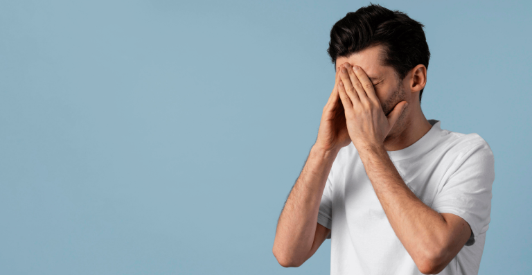 Man feeling stressed and overwhelmed while working at laptop