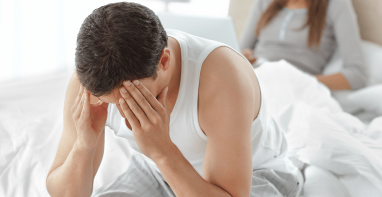 Man feeling stressed and overwhelmed while working at laptop